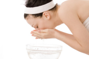 woman washing her face with water
